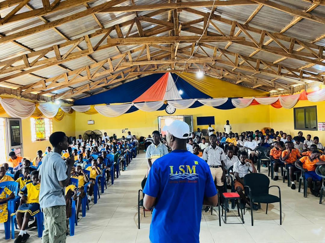 Young people gathered in the church hall with a ministry leader